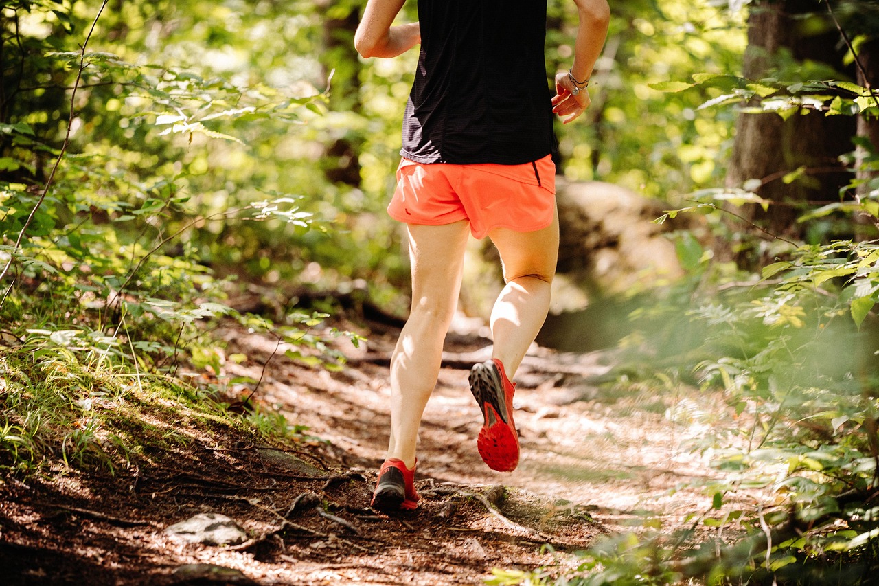Mujer corriendo en el bosque con energía Nipponflex
